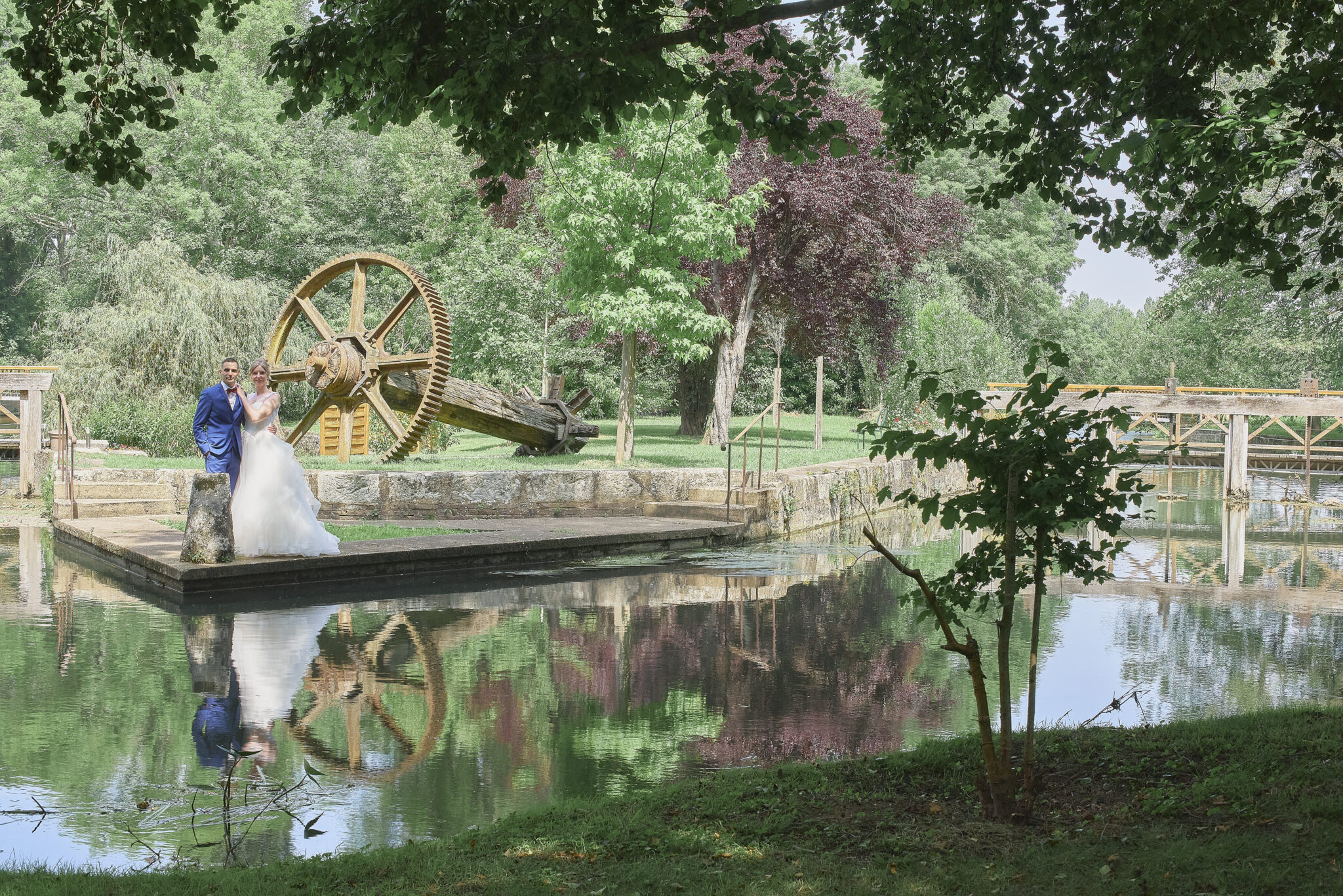 Mariés qui dansent au bord de l'eau, avec leurs reflets dans l'eau